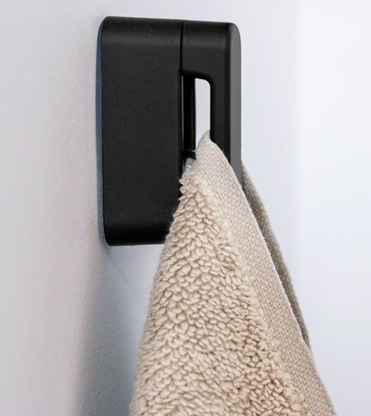 Schwarzer Handtuchhaken mit Handtuch an der Wand