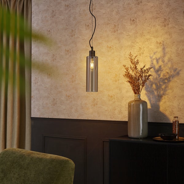 Hängelampe mit zylindrischem Glasschirm über einem Sideboard