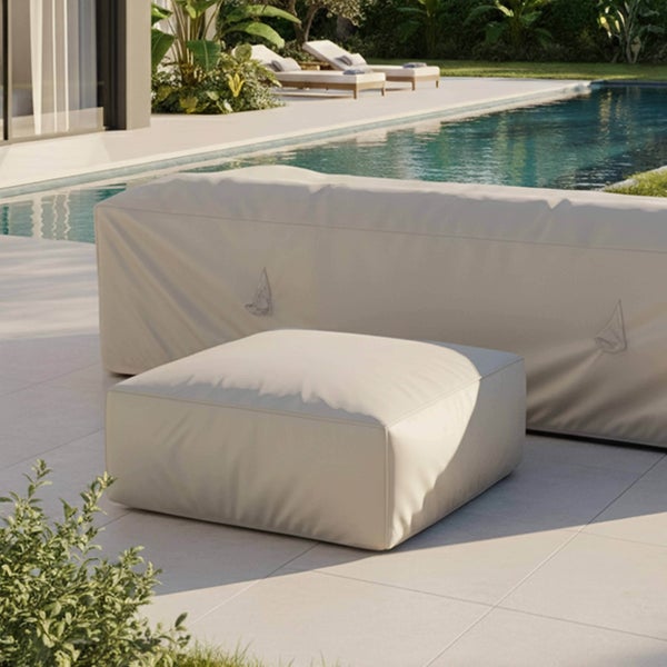 Schutzhülle für Garten-Lounge-Sofa und Hocker auf einer hellen Terrasse am Pool.