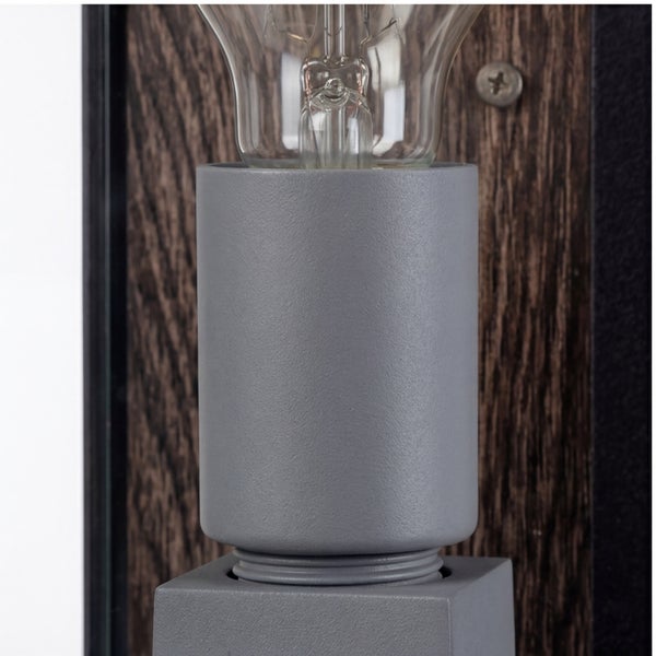 Detailansicht einer grauen Lampenfassung mit Glühbirne auf einer Wandhalterung aus dunklem Holz.