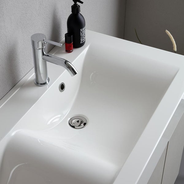 Modernes weißes Keramik Waschbecken mit glänzender Waschtischarmatur in einem Badezimmer.