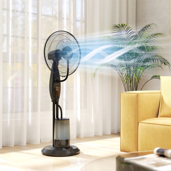 Schwarzer Sprühnebel-Standventilator mit Wassertank in einem hellen Wohnzimmer mit gelbem Sofa und Zimmerpflanze.