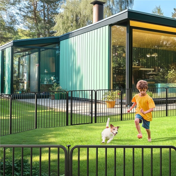 Kind und Hund spielen in einem Garten, der von einem schwarzen Metallzaun umgeben ist.