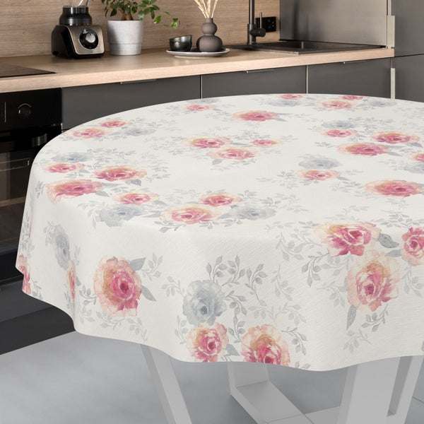 Runde Tischdecke mit Blumenmuster aus Rosen und Blättern in einer modernen Küche mit dunklen Schränken und Holz-Arbeitsplatte.
