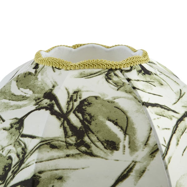 Detail eines Lampenschirms aus Stoff mit floralem Muster und goldener Zierborte am oberen Rand.