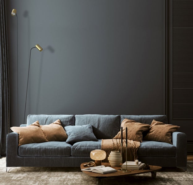 Wohnzimmer mit Sofa, Kissen, Couchtisch und Stehlampe für eine gemütliche Atmosphäre