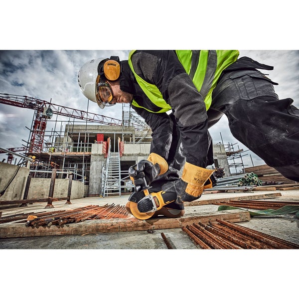 Bauarbeiter auf einer Baustelle schneidet Metallstangen mit einem Winkelschleifer und trägt dabei Schutzausrüstung.