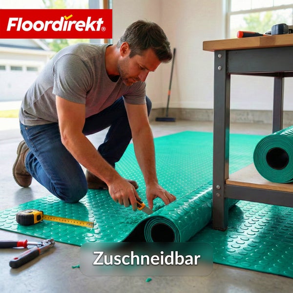 Ein Mann schneidet eine grüne Bodenschutzmatte mit Noppenstruktur in einer Garage zu. FloorDirekt Logo.