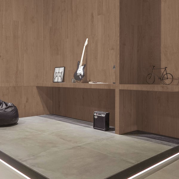 Modernes Zimmer mit Wandfliesen in Holzoptik und großen Bodenfliesen in Betonoptik. Ein eingebautes Regal und minimalistisches Design.