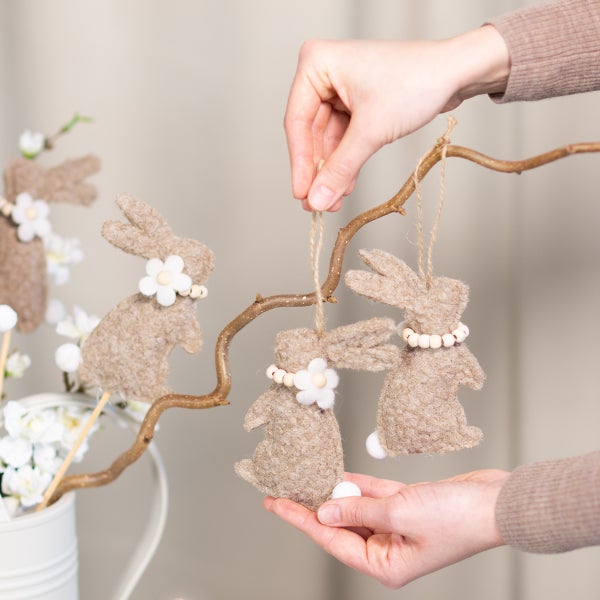 Dekorierter Osterstrauch mit Hasenanhängern in Filzoptik