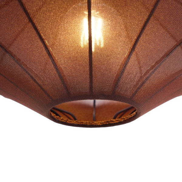 Nahaufnahme eines braunen Lampenschirms aus feinmaschigem Stoff mit eingeschaltetem Leuchtmittel.