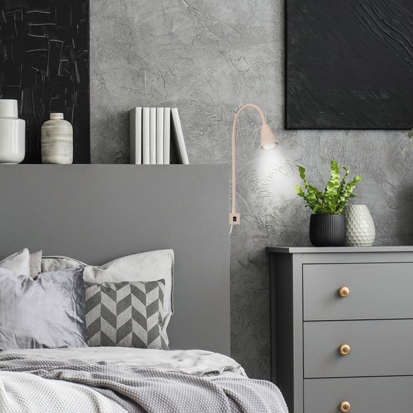 Schlafzimmer mit Bett, Nachttisch und flexibler Wandleuchte