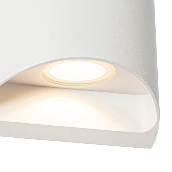 Detailaufnahme einer weißen, geschwungenen Wandleuchte mit integriertem LED-Modul und warmweißem Licht.