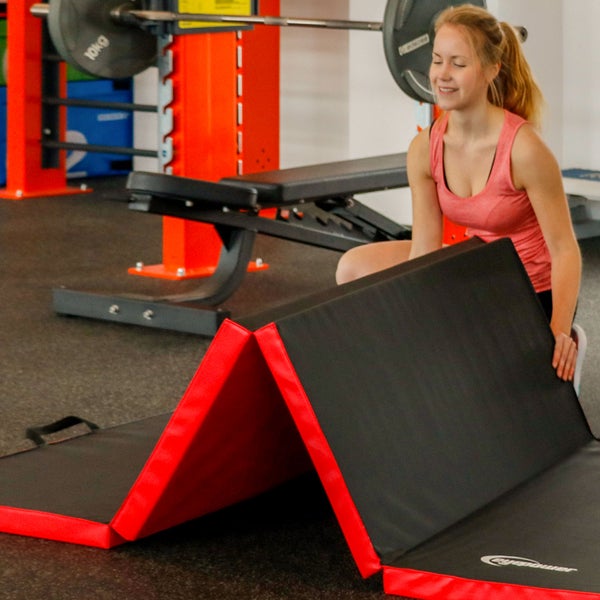 Gymnastikmatte im Fitnessstudio mit trainierender Frau