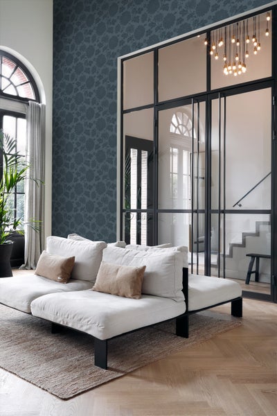 Wohnzimmer mit Sofa, Teppich und gemusterter Tapete