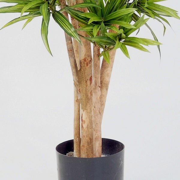 Künstliche Pflanze mit Stämmen aus Echtholz und grünen Blättern in einem schwarzen Topf.