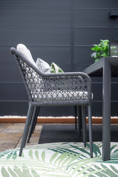 Gartenstuhl mit Seilgeflecht, Metallgestell und Sitzkissen auf einer Terrasse.