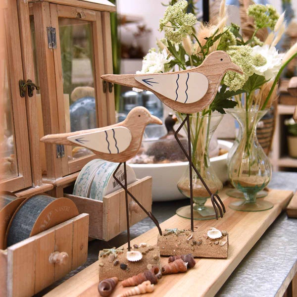 Dekorative Holzfiguren in Vogelform mit Metallsockel und Muscheldekoration als Tischdekoration