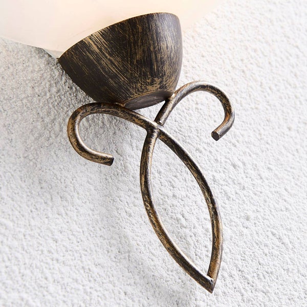 Detail einer Wandleuchte mit dekorativem Metallelement in antikem Finish.