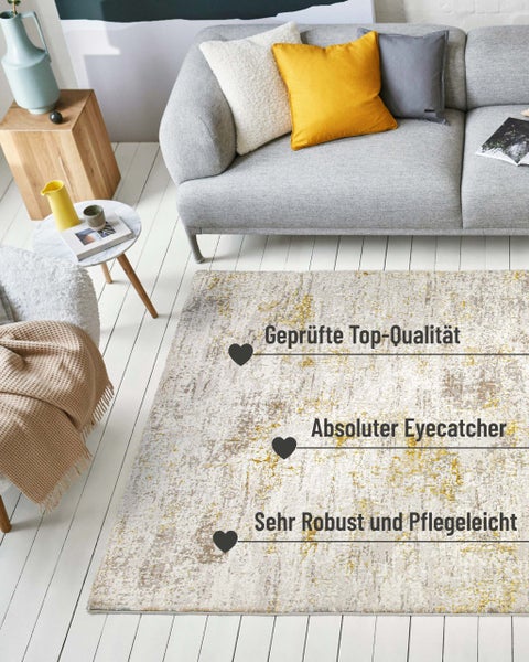 Moderner Teppich mit Vintage-Muster in Grau und Gelb vor einem grauen Sofa im hellen Wohnzimmer. Der Teppich ist robust und pflegeleicht.