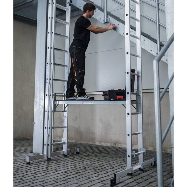 Mann arbeitet auf einem Aluminium Gerüst an einer Metallkonstruktion.