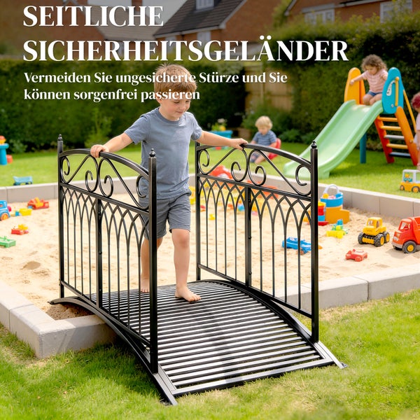 Kleine schwarze Gartenbrücke aus Metall mit seitlichen Sicherheitsgeländern über einem Sandkasten mit spielendem Kind in einem hellen Garten.