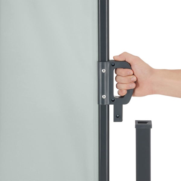 Hand am Griff einer ausziehbaren Seitenmarkise zum Einhängen in den Standpfosten.