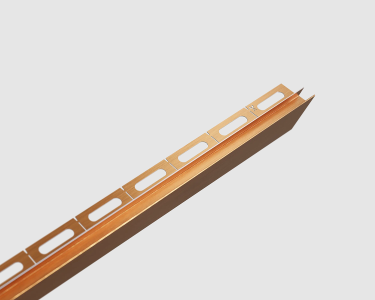 Fliesenschiene Eckprofil aus Metall in Kupferoptik mit gelochtem Befestigungsschenkel.