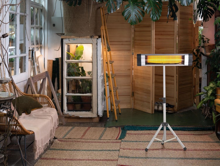 Innenraum mit Heizstrahler auf Stativ, Rattansofa und Dekorationen