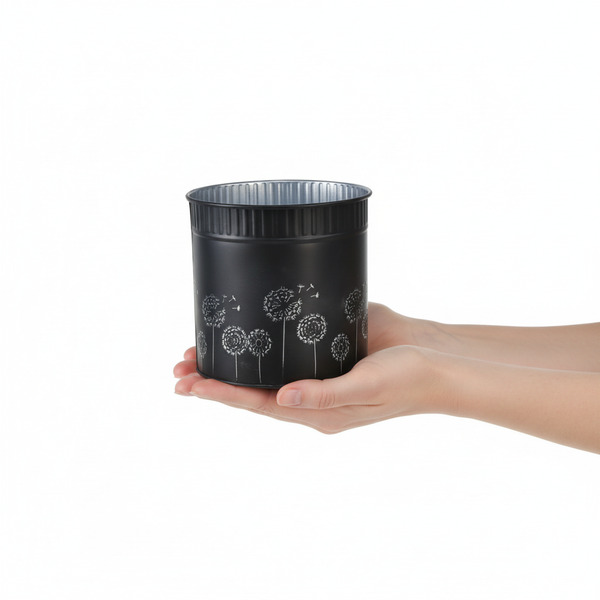 Dekorativer runder Metall-Übertopf mit Pusteblumen-Motiv, in Händen gehalten zur Größenveranschaulichung.