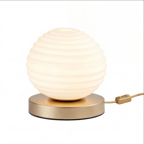 Kugelförmige Tischleuchte mit geripptem Schirm aus Milchglas und einem messingfarbenen Metallsockel inklusive Kabel mit Schalter.