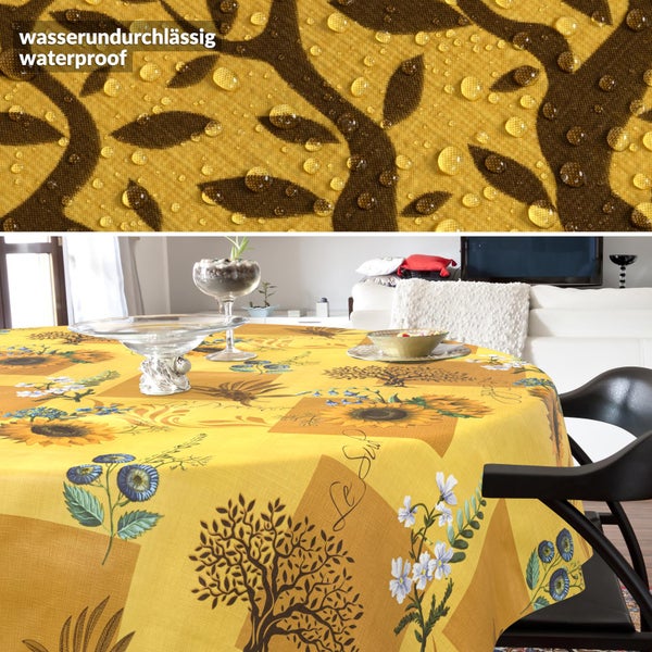 Wasserabweisende Tischdecke mit Sonnenblumen- und Baummuster auf einem runden Tisch. Detailansicht zeigt wasserundurchlässiges Material mit Wassertropfen.