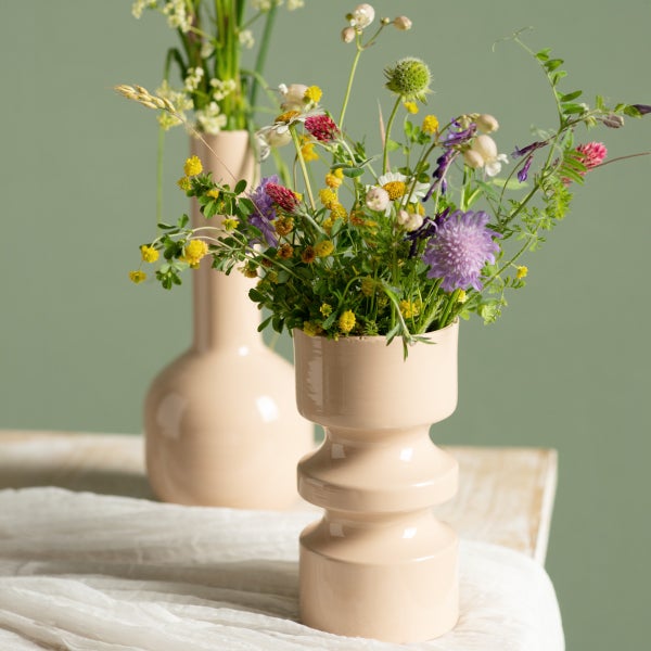 Dekorative Vasen mit Wildblumen auf einem Tisch