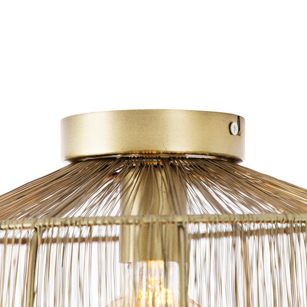 Nahaufnahme einer goldenen Deckenleuchte mit Metalldrahtschirm