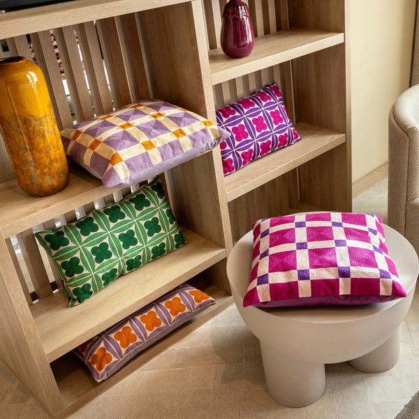 Dekoratives Regal mit Kissen und Vasen