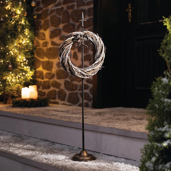 Dekorativer Metallständer mit Weidenkranz für die weihnachtliche Außendekoration vor einem Hauseingang