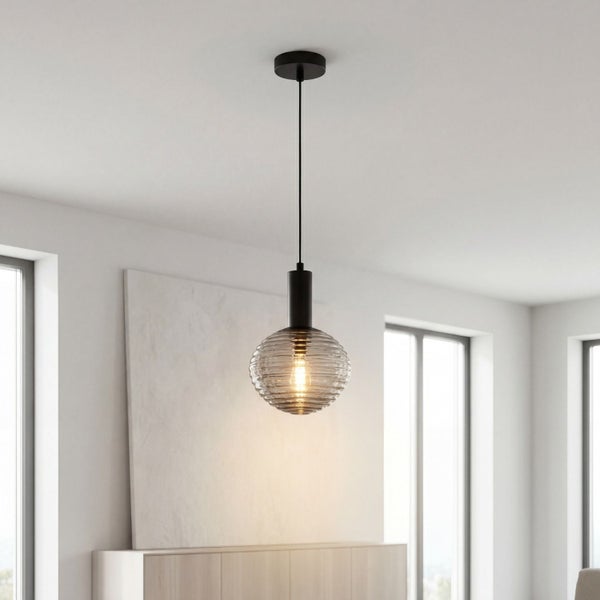 Moderne Hängeleuchte mit einem runden, gerillten Glasschirm und schwarzer Aufhängung in einem hellen, minimalistischen Raum.