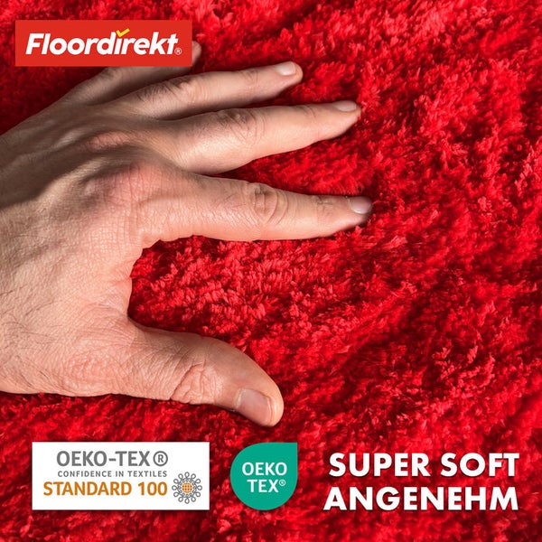 Hand berührt roten Teppich von Floordirekt mit Öko-Tex Siegel