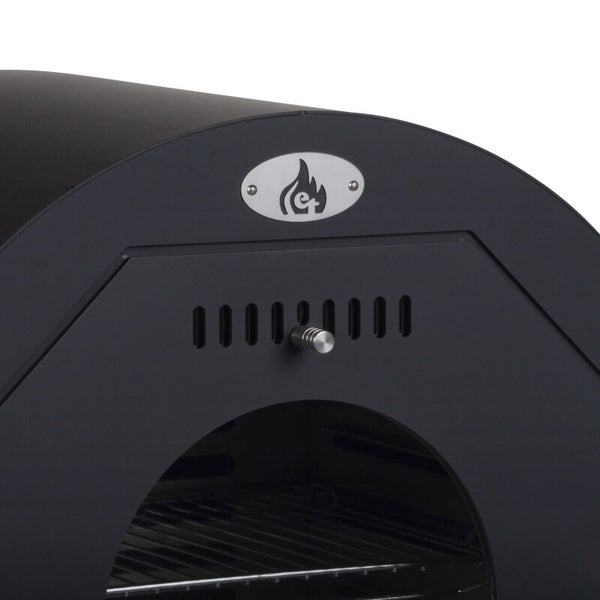 Nahaufnahme eines schwarzen Außenofens mit Lüftungsschlitzen, et Logo und Grillrost im Inneren.