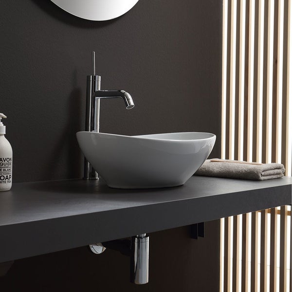 Modernes Badezimmer mit ovalem Aufsatzwaschbecken aus Keramik und hoher Chrom-Armatur auf dunkler Waschtischplatte vor Holzlamellen.