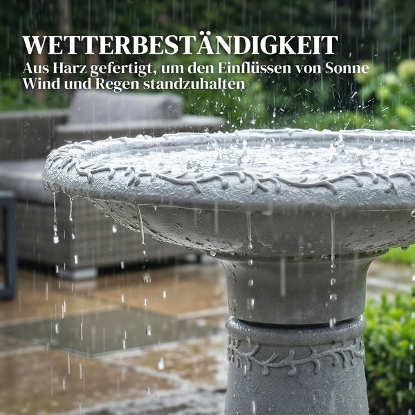 Wetterbeständige Vogeltränke aus Harz mit Ornamenten in einem Garten bei Regen, hält Einflüssen von Sonne, Wind und Niederschlag stand.