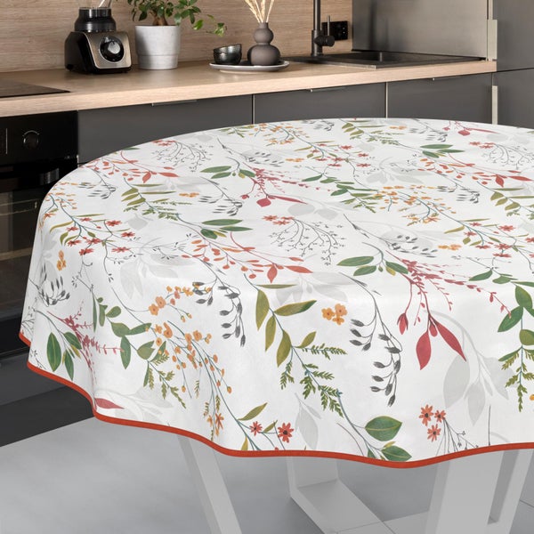 Runde Tischdecke mit botanischem Muster aus Blättern und kleinen Blüten in einer modernen Küche.