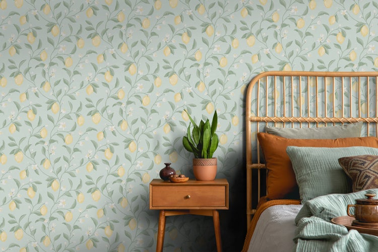 Schlafzimmer mit Rattanbett und Nachttisch vor einer Zitrone-Motivtapete.