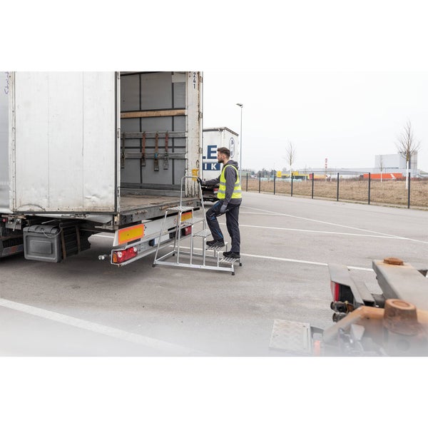 Eine Person benutzt eine mobile Treppe zum Beladen eines Lkw.