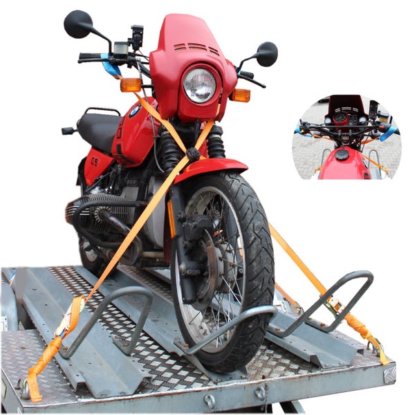 Motorrad auf einem Anhänger mit Spanngurten zur Ladungssicherung befestigt.