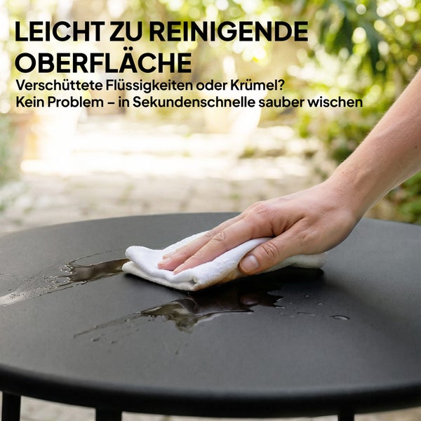Moderner schwarzer Couchtisch mit zwei gepolsterten Gartensesseln auf einer hellen Terrasse im Garten.