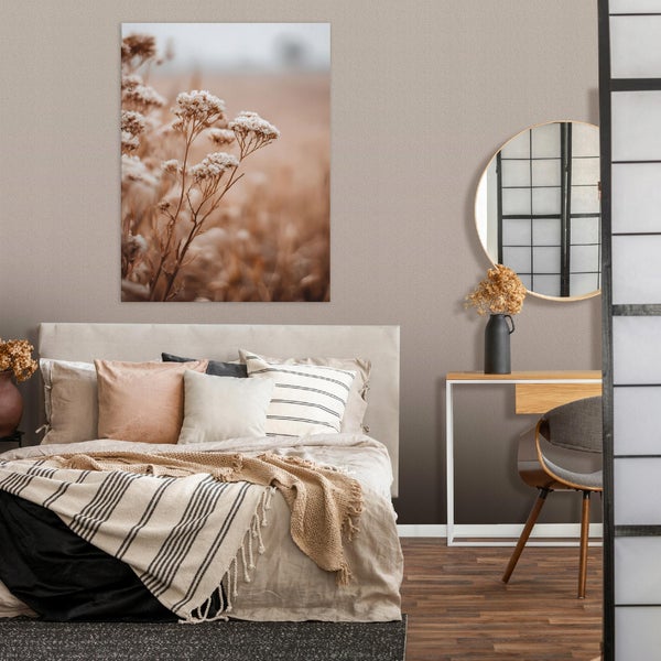 Modernes Schlafzimmer mit Doppelbett, Wandbild mit Naturmotiv, rundem Spiegel, Konsolentisch und Stuhl in neutralen Erdtönen.