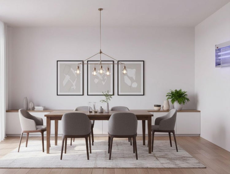 Helles modernes Esszimmer mit Holztisch, grauen Stühlen, mehrflammiger Pendelleuchte und an der Wand montiertem Insektenvernichter.
