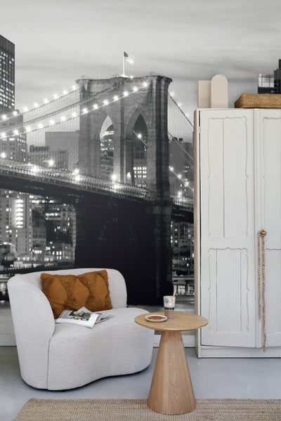 Wohnzimmer mit Sessel, Beistelltisch und Fototapete mit Brückenmotiv