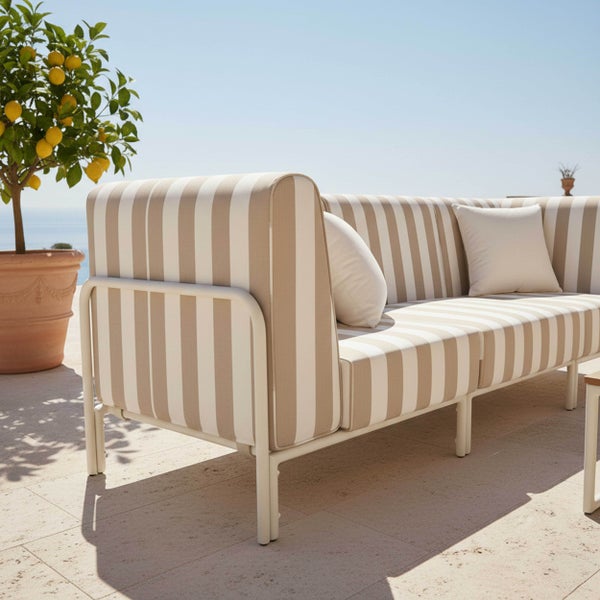 Modernes Outdoor-Sofa mit gestreiften Polstern auf einer hellen Terrasse neben einem Zitronenbaum im Tontopf.